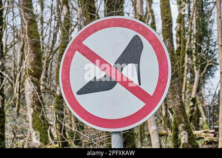 Straßenschild, das unbequeme Wanderschuhe verbietet. Stockfoto