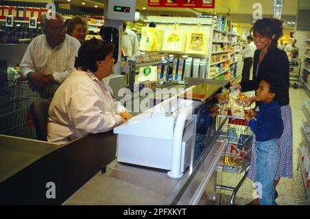 Mutter und Sohn an der Kasse im Tesco Supermarkt England Stockfoto