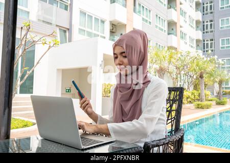 Frau mit Dish dasha, die in seinem Geschäftsbüro in Dubai arbeitet. Porträts eines erfolgreichen Geschäftsmannes in traditionellem emiratskleid. Konzept Abou Stockfoto