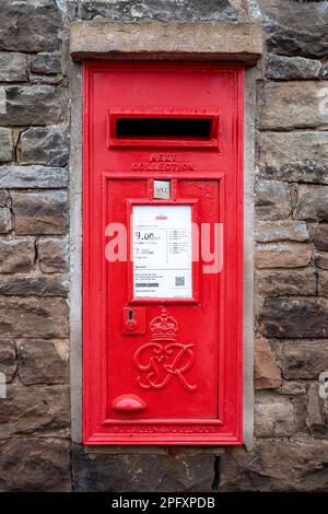 „Changing Times“, Post und Royal, eingebettet in eine Sandsteinmauer, Brunswick Square, Penrith, Cumbria, Großbritannien Stockfoto