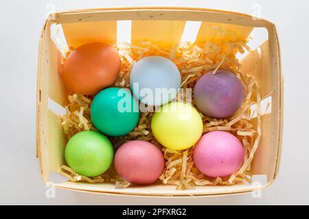 Viele bunte, helle, handgemachte Seifeneier in Körben aus Furnier. Stockfoto