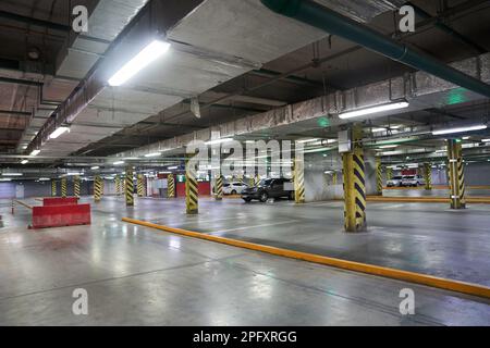 Selektiver Fokus auf Tiefgaragenparkplätze in einem Einkaufszentrum. Parkbeschränkungen. Mit einem Platz zum Kopieren. Navigation auf dem Parkplatz. Kostenloser Parkplatz. Hochwertiges Foto Stockfoto