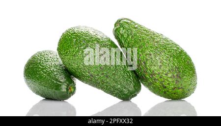 Drei dunkelgrüne, reife organische Avocados, Makro, isoliert auf weißem Hintergrund. Stockfoto
