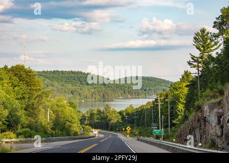 Die Straße zu einem großen See, umgeben von Wäldern Stockfoto