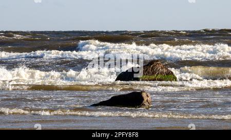 Ostsee mit weißen Wellen und zwei dunklen Steinen im Meerwasser Stockfoto