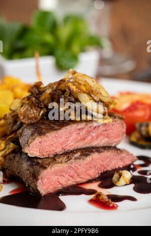 Scheiben von einem gegrillten Steak mit Pommes Frites Stockfoto