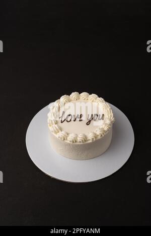 Kleiner weißer Kuchen auf schwarzem Hintergrund Stockfoto
