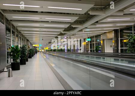 Flughafen Schiphol, Niederlande 2023 leerer bewegender Bürgersteig oder Fußweg im Flughafen Schiphol Amsterdam Terminal aufgrund der Coronavirus Pandemie Abriegelung keine Menschen, aber sehr saubere Oberflächen und Stille Stockfoto