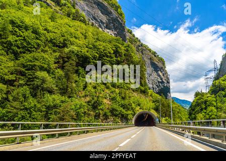 Straße zwischen den Alpen mit einem toonel in einem Felsen, Klosters-Serneus, Davos, Graubuenden Schweiz. Stockfoto