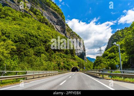 Straße zwischen den Alpen mit einem toonel in einem Felsen, Klosters-Serneus, Davos, Graubuenden Schweiz. Stockfoto