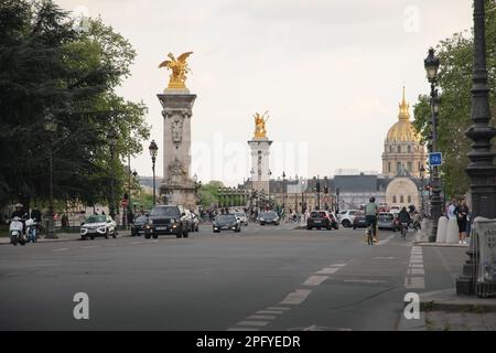 Blick auf die Straße und die Brücke Pont Alexandre mit der goldenen Kuppel des Invalidendoms in Paris. Stockfoto