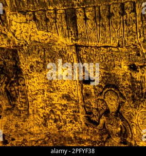Die Royston Cave in Herfordshire, Großbritannien, verwirrt heute noch Historiker. Die Höhle ist mit einer großen Anzahl von Wandskulpturen mit niedrigem Relief dekoriert. Es sind hauptsächlich christliche Motive im mittelalterlichen Stil. Die Figur mit dem gezogenen Würm könnte den Heiligen Michael oder vielleicht den Heiligen Georg repräsentieren, der später Schutzpatron von England war. Der Würfel der Figur zeigt auf das, was Jasus und die zwölf Jünger mit Judas zu sein scheinen, die kleine Figur hinten am rechten Ende der Reihe. Royston Cave in Katherine's Yard, Melbourn Street, Royston, England Stockfoto