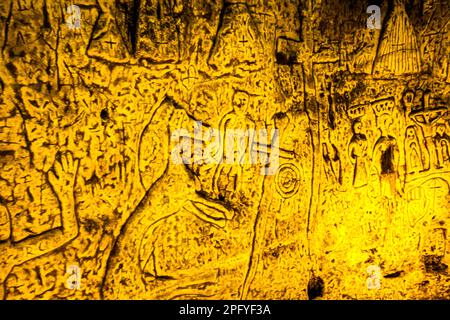 Die Royston Cave in Herfordshire, Großbritannien, verwirrt heute noch Historiker. Die Höhle ist mit einer großen Anzahl von Wandskulpturen mit niedrigem Relief dekoriert. Es sind hauptsächlich christliche Motive im mittelalterlichen Stil. Oben links ist eine Kreuzigung dargestellt. Royston Cave in Katherine's Yard, Melbourn Street, Royston, England Stockfoto