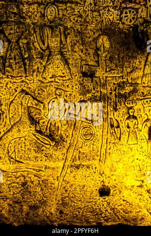 Die Royston Cave in Herfordshire, Großbritannien, verwirrt heute noch Historiker. Die Höhle ist mit einer großen Anzahl von Wandskulpturen mit niedrigem Relief dekoriert. Es sind hauptsächlich christliche Motive im mittelalterlichen Stil. Royston Cave in Katherine's Yard, Melbourn Street, Royston, England Stockfoto