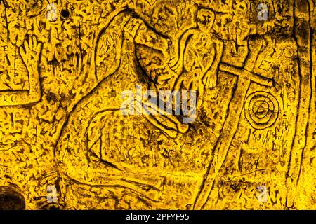 Die Royston Cave in Herfordshire, Großbritannien, verwirrt heute noch Historiker. Die Höhle ist mit einer großen Anzahl von Wandskulpturen mit niedrigem Relief dekoriert. Es sind hauptsächlich christliche Motive im mittelalterlichen Stil. Oben links ist eine Kreuzigung dargestellt. Royston Cave in Katherine's Yard, Melbourn Street, Royston, England Stockfoto
