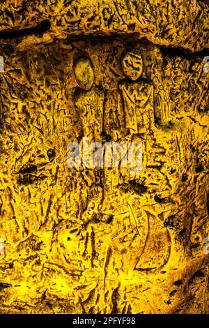 Die Royston Cave in Herfordshire, Großbritannien, verwirrt heute noch Historiker. Die Höhle ist mit einer großen Anzahl von Wandskulpturen mit niedrigem Relief dekoriert. Es sind hauptsächlich christliche Motive im mittelalterlichen Stil. Oben links ist eine Kreuzigung dargestellt. Royston Cave in Katherine's Yard, Melbourn Street, Royston, England Stockfoto