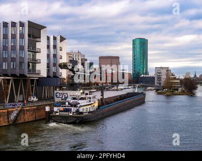 Frankfurt am Main, Deutschland - 29. Januar 2023: Industrieschiff vor dem Wohnbereich des Westhafens in Frankfurt am Main, Deutschland, bei bewölktem Wetter. Stockfoto