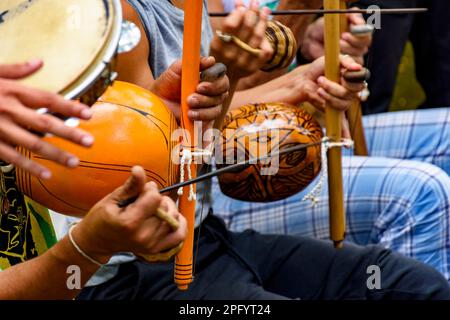 Mehrere afro-brasilianische Perkussion-Musikinstrumente während einer Capoeira-Vorstellung in den Straßen Brasiliens Stockfoto