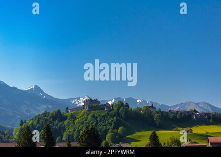 Burg Gruyeres inmitten von Wald- und Grünwiesen in Haut-Intyamon, Greyere, Freiburg, Schweiz. Stockfoto