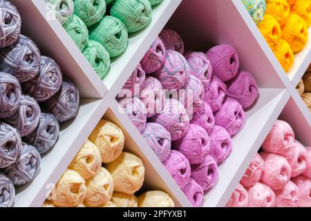 Balls of multicolor wool, assortment of yarn on display in the store. Sale of yarn for knitting beautiful wool sweaters. Stockfoto