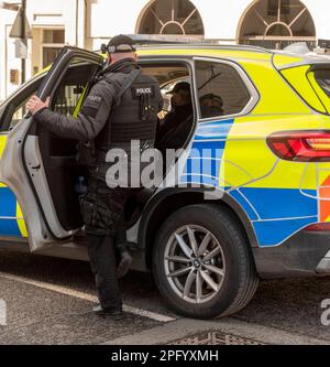 Windsor, Berkshire, England, Großbritannien. 2023. Bewaffneter Polizist steigt in einen Streifenwagen. Stockfoto