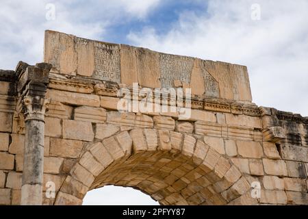 Blick auf die Inschrift auf dem Triumphbogen, erbaut zu Ehren des Kaisers Carcalla in Volubilis Stockfoto