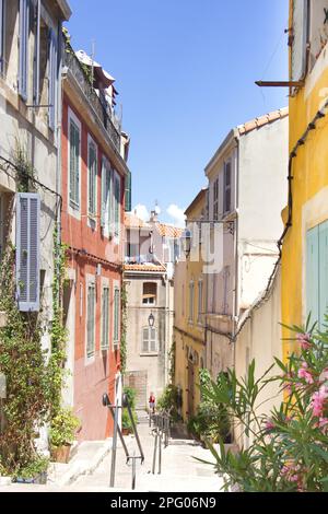 Farbenfrohe Häuser entlang der engen Gassen in Marseille mit warmem Sonnenlicht und blauem Himmel Stockfoto