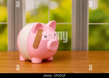 Sparschwein mit Verband. Pensionierung, Bankversagen, finanzielle Gesundheit und Planungskonzept. Stockfoto