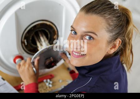 Weibliche Klempner Arbeiten an zentralen Heizkessel Stockfoto