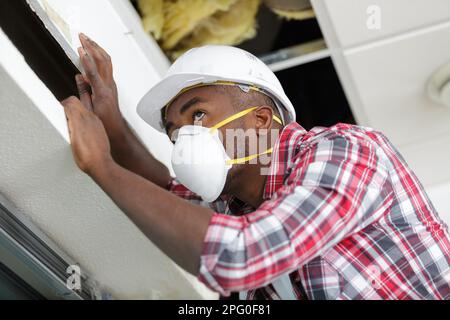 Ein Mann, der das Grundstück inspiziert und eine Maske über dem Mund trägt Stockfoto