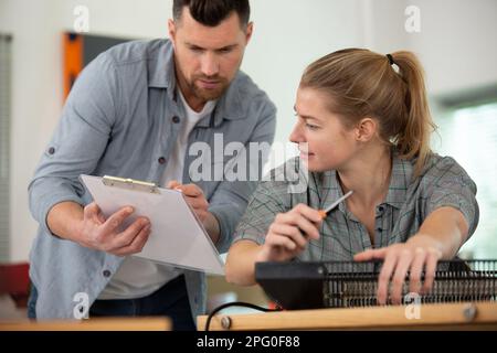 Eine Frau in der Hocke mit einem Soldaten, der das Klemmbrett überprüft Stockfoto