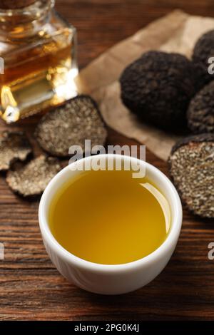 Frisches Trüffelöl in Schüssel auf Holztisch Stockfoto