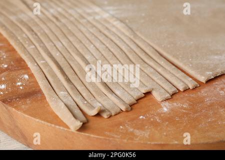 Hausgemachte Soba (Buchweizennudeln) auf Holzbrett, Nahaufnahme Stockfoto