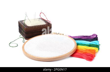 Bunte Fäden und verschiedene Stickereien auf weißem Hintergrund Stockfoto