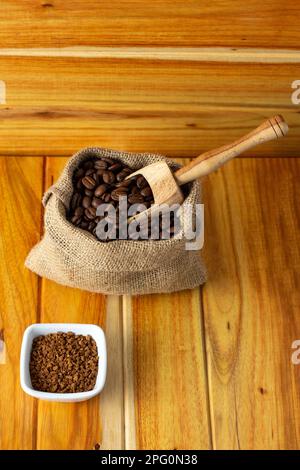 Frische Kaffeebohnen in Stoffsäcken - Sack mit Kaffeebohnen und Holzlöffel Stockfoto