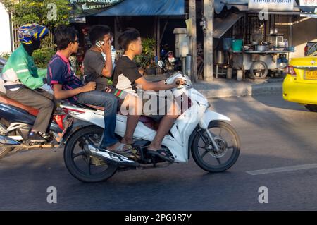 SAMUT PRAKAN, THAILAND, 28 2023. JANUAR, Ein Trio junger Männer, die nachmittags auf der Straße ein Motorrad fahren Stockfoto