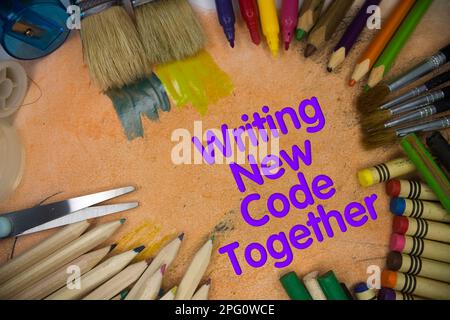 Overhead-Aufnahme von Schulmaterial beim Schreiben von „New Code Together“-Text. Pinsel, Bleistifte, künstlerische Werkzeuge. Kunst- Und Handwerksgeräte. Stockfoto