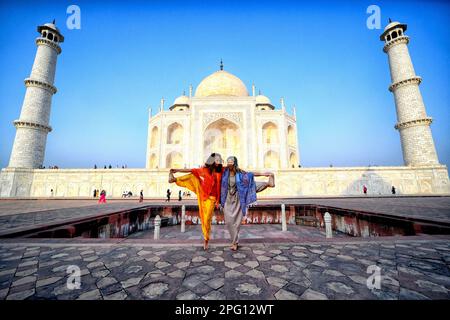 2. März 2023, Agra, Uttar Pradesh, Indien: Ausländische Touristen, die sich vor dem Taj Mahal in Agra in verschiedenen Yoga (körperliche Bewegung) posieren sehen. Das Taj Mahal ist ein Mausoleum am rechten Ufer des Flusses Yamuna - Agra, Indien, erbaut vom Mogul-Kaiser Shah Jahan zum Gedenken an seine Lieblingsfrau Mumtaz. Das Taj Mahal gilt als das beste Beispiel der Mogul-Architektur, ein Stil, der Elemente aus persischen, oman-, indischen und islamischen Architekturstilen kombiniert. Das Taj Mahal steht auf der Liste der modernen sieben Weltwunder und gehört auch zum UNESCO-Weltkulturerbe Stockfoto