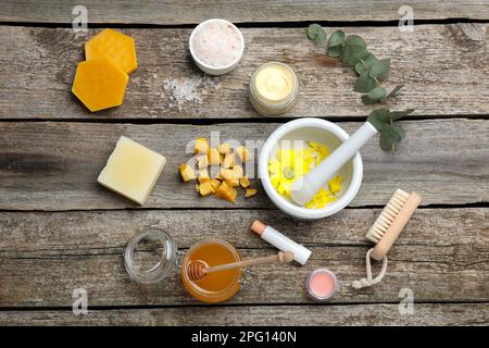 Flachliegenzusammensetzung mit Bienenwachs und kosmetischen Mitteln auf Holztisch Stockfoto