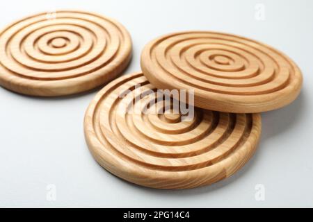 Stilvolle Untersetzer aus Holzbechern auf hellem Hintergrund Stockfoto