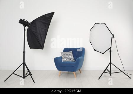 Komfortabler Sessel und professionelle Beleuchtungsausstattung im Fotostudio Stockfoto