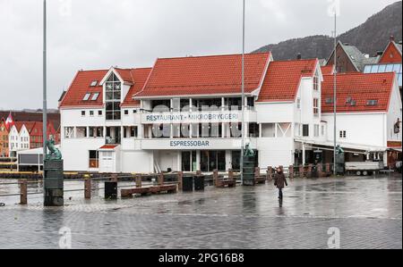 Bergen, Norwegen - 17. November 2017: Blick auf die Küste von Bergen mit Restaurantgebäude. Gewöhnliche Leute gehen die Straße entlang Stockfoto