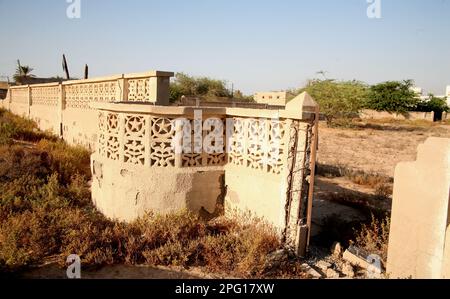 Zerbrochene Mauer um den Innenhof einer alten Moschee im Dorf Al Jazirat al Hamra in Ras al Khaimah. Das Dorf wurde 1968 verlassen. Stockfoto