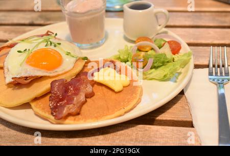 Leckeres Frühstück mit Pfannkuchen im sonnenbeleuchteten Café. Stockfoto