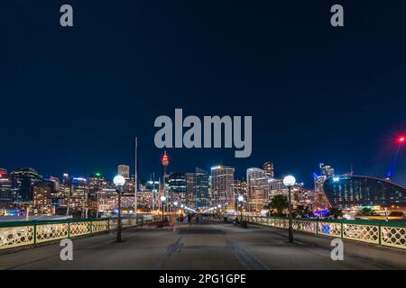 Sydney, Australien - 16. April 2022: Beleuchtete Skyline von Sydney bei Nacht von der Pyrmont Bridge durch Darling Harbour Stockfoto