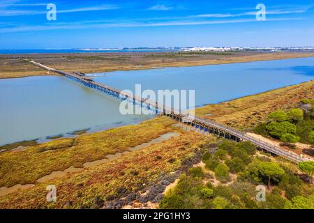 Luftaufnahme auf Marschland und Salzwerk, Naturpark Bahia de Cadiz. Costa de la Luz, Provinz Cadiz, Andalusien, Spanien. Die Holzbrücke über die Sa Stockfoto