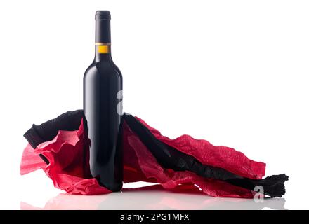 Flasche Rotwein mit zerknittertem roten und schwarzen Krepppapier, isoliert auf weißem Hintergrund. Stockfoto