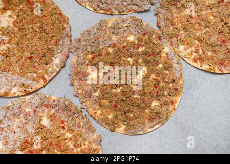 Verzehrfertiger gefrorener Lahmacun auf Backpapier auf einem Backblech Stockfoto