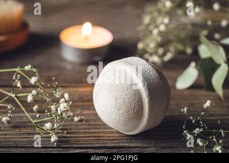 Spa-Komposition mit Badebombe, Kerze und getrockneten Blumen. Stockfoto