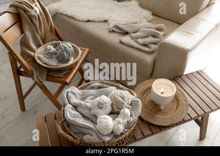 Fäden zum Stricken im Innenraum, eine gemütliche Komposition mit Garn. Stockfoto